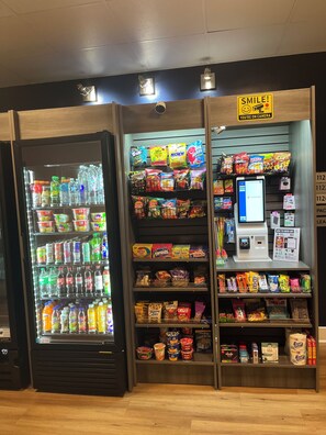 Un distributeur automatique proposant des collations, des boissons et un terminal de paiement.