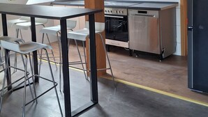 Una cocina moderna con tragaluz, electrodomésticos de acero inoxidable y un comedor con mesa y sillas.