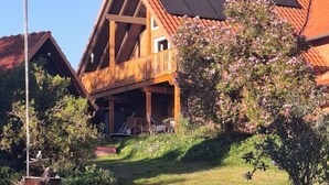 Una casa de madera con techo inclinado, balcón y chimenea.
