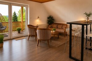 A cozy living room with a sofa, two armchairs, a coffee table, and a dining area with stools. - Landhaus Korf - Holiday apartment in the Weserbergland with large balcony (Extertal)