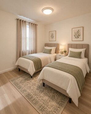 Een hotelkamer met twee bedden, een groot vloerkleed en een plafondlamp.
