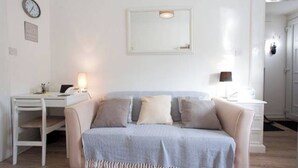 Quarto minimalista com cama, escrivaninha e cadeira.