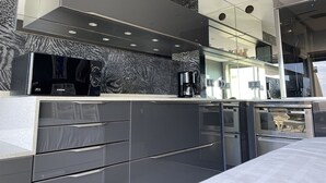 A modern kitchen with a built-in microwave, coffee maker, and oven. - CAP-Y-SUN - Studio Héliopolis O18 - Luxe - 2 people (AGDE)