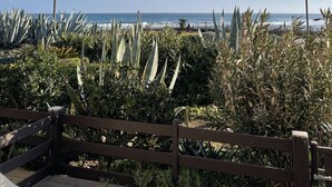 A coastal view with a wooden fence, various plants, and a clear sky. - CAP-Y-SUN - Studio Héliopolis O18 - Luxe - 2 people (AGDE)