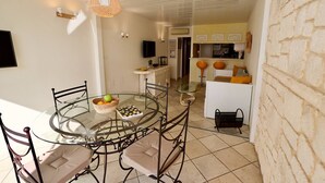 A dining area with a glass table, metal chairs, a wicker basket with fruit, and a notebook. - SESAME - Apartment Port Ambonne PA122 - Luxe - 4 people (AGDE)