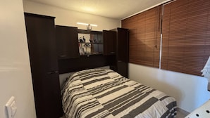 A bedroom with a bed, a wardrobe, a shelf unit, and a window with blinds. - ZEN - Port Ambonne Apartment  PA311 - Luxury - 2 people (AGDE)