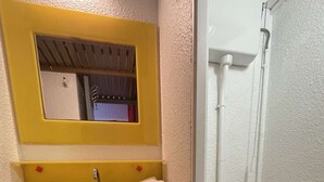 Ein Badezimmer mit einem gelben Waschbecken, einer weißen Toilette und einem Spiegel über dem Waschbecken.