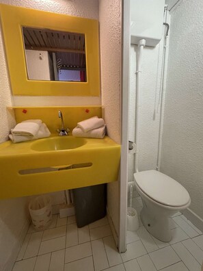 A bathroom with a yellow sink, a white toilet, and a mirror above the sink. - Port Nature Studio 54 - 2 people (AGDE)