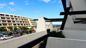 Ein Hotel mit Parkplatz, ein großes Gebäude im Hintergrund und ein klarer Himmel.