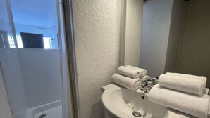 A bathroom with a white sink, a mirror, and a shower. - Port Nature Studio 67 - 2 people (AGDE)