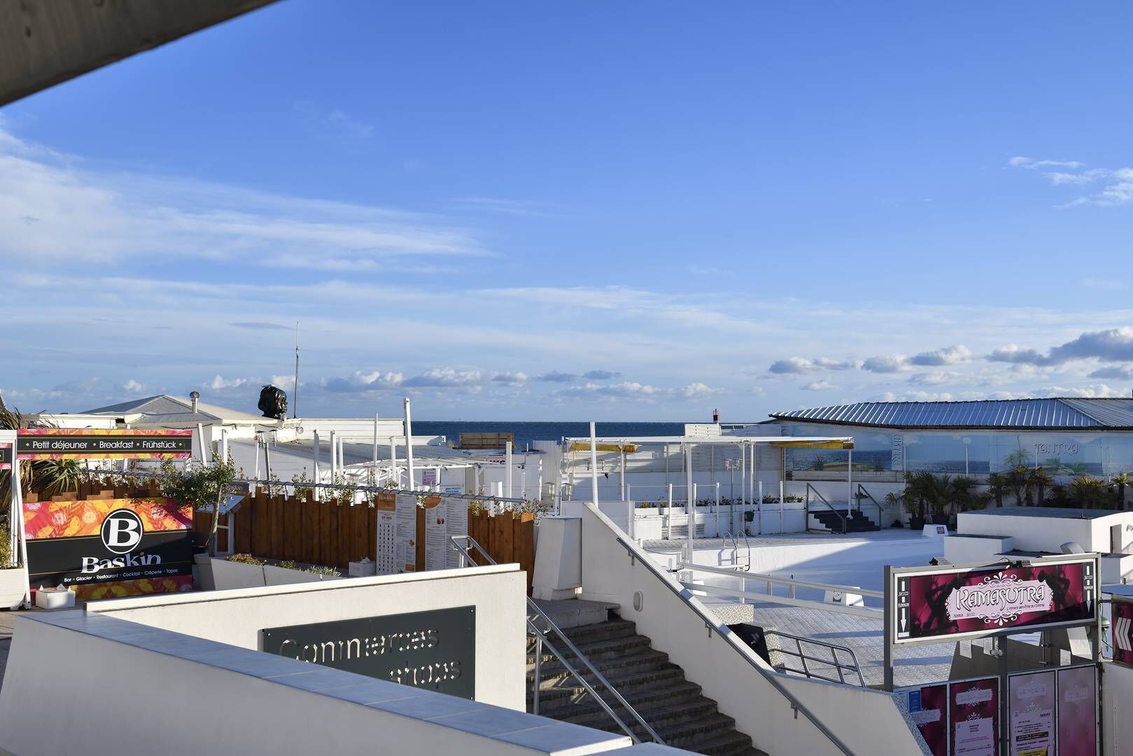 Terraza en la azotea con vista al mar, un letrero de Baskin y un letrero de Ramesotra.