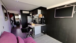 A modern living space with a kitchen, a dining area, and a seating area with a sofa. - DIAMANT - Port Nature Apartment 81 - Luxury - 2 people (AGDE)