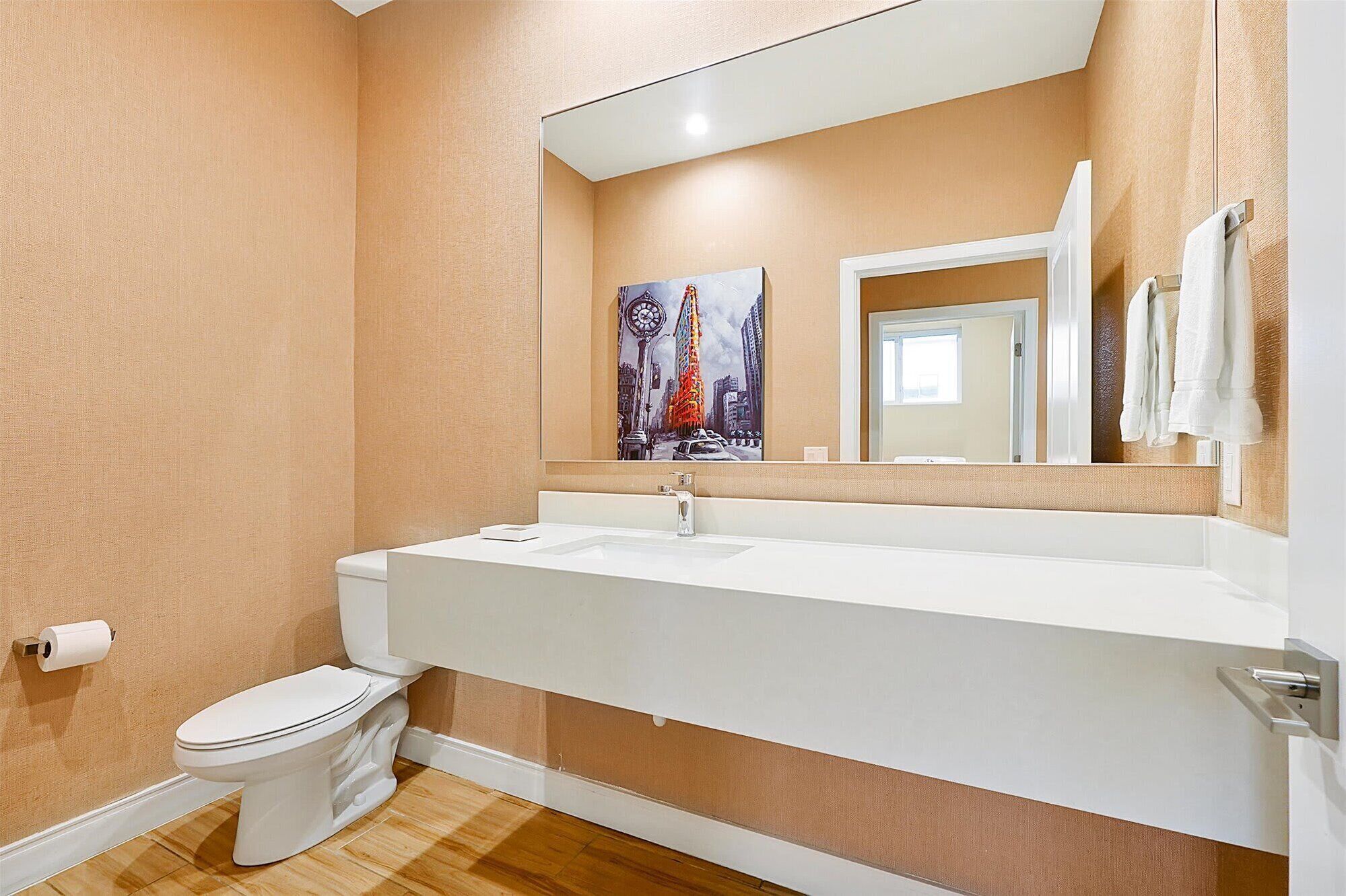 Une salle de bain avec un lavabo blanc, un miroir et des toilettes.
