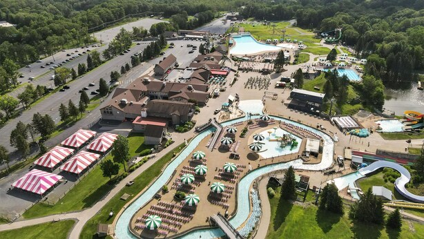 Vue aérienne d’un complexe hôtelier doté d’une piscine, de toboggans aquatiques et d’un parking.
