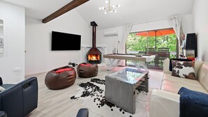 Un salon moderne avec une cheminée, une table de billard et un canapé.