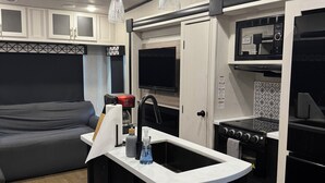A compact kitchen with a central island, built-in microwave, and oven.