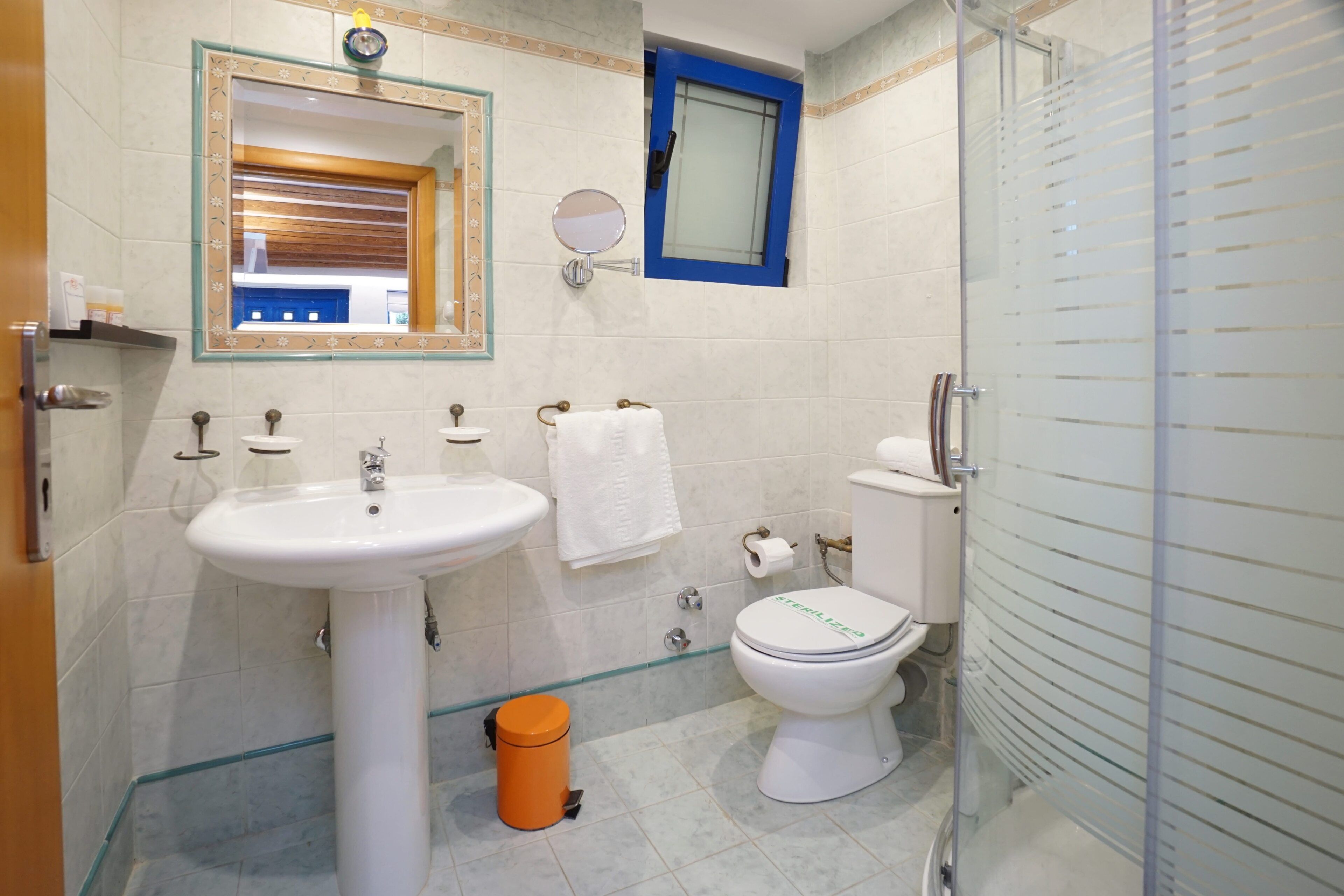 Ein Badezimmer mit Waschbecken, Toilette und Spiegel.