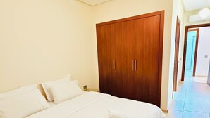 Ein Schlafzimmer mit einem großen Bett, einem Holzschrank und einem Flur, der zu einem weiteren Raum führt.