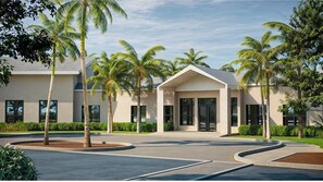 A modern building with a central entrance, surrounded by palm trees and a landscaped area. - 2946 BY - Wellness Ridge Sanctuary (Clermont)