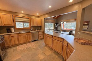A modern kitchen with wooden cabinets, a dishwasher, and a large island.