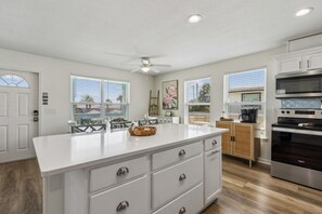 A modern kitchen with a large island, built-in appliances, and large windows. - Updated 6-bedroom, 4 bath cottage across from the beach with a private pool (Fernandina Beach)