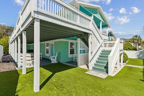 A two-story house with a covered porch, a staircase, and a well-maintained lawn. - Updated 6-bedroom, 4 bath cottage across from the beach with a private pool (Fernandina Beach)