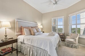 A bedroom with a bed, bedside lamps, a chair, and a window with blinds. - Oceanfront Penthouse Retreat – 7th Floor at Ocean Place (Fernandina Beach)