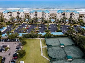 A beachfront hotel with multiple buildings, a parking lot, and a tennis court. - Oceanfront Penthouse Retreat – 7th Floor at Ocean Place (Fernandina Beach)