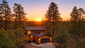Ein zweistöckiges Haus mit Garage, umgeben von einem Wald.