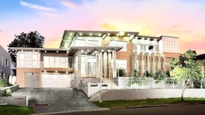 A modern two-story building with a garage, a staircase, and a well-maintained lawn. - The Bella Nest - Bella Vista (Sydney)