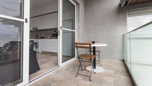 A modern kitchen with a washing machine, a microwave, and a sink. - The Bella Nest - Bella Vista (Sydney)
