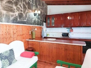 A compact kitchen with wooden cabinets, a microwave, and a small countertop.