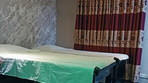 A room with a bed, a small table, and a curtain.