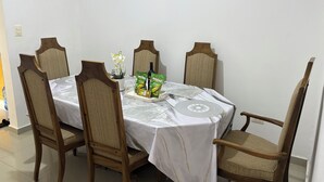 A dining table with a white tablecloth, surrounded by wooden chairs with cushioned seats. - Apartment in La Vega, 20 minutes from the Fula river. (Concepcion De La Vega)