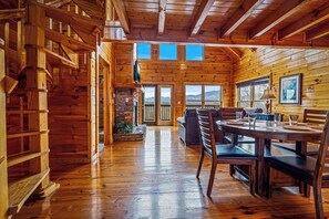 Ein Blockhaus-Interieur mit Essbereich, Holzwänden und Blick durch die Türen.