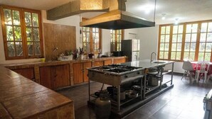 A kitchen with a gas stove, wooden cabinets, and large windows.