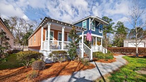 Et tosyltet hus med en veranda og et amerikansk flag.