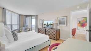 A hotel room with a bed, a TV, a desk, and a chair.
