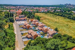 An aerial view of a residential area with terraced houses, a swimming pool, and surrounding greenery. - Villa Lotus 6 with private pool and jacuzzi. (Pula)