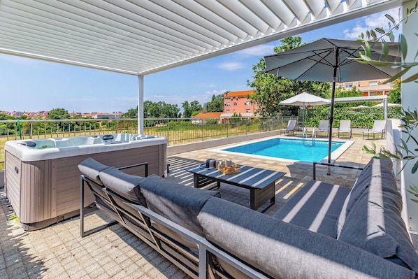 A rooftop pool area with a hot tub, lounge chairs, and umbrellas. - Villa Lotus 6 with private pool and jacuzzi. (Pula)
