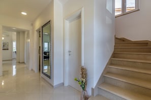 A hallway with a mirrored door, a staircase, and a vase with flowers. - Villa Lotus 6 with private pool and jacuzzi. (Pula)