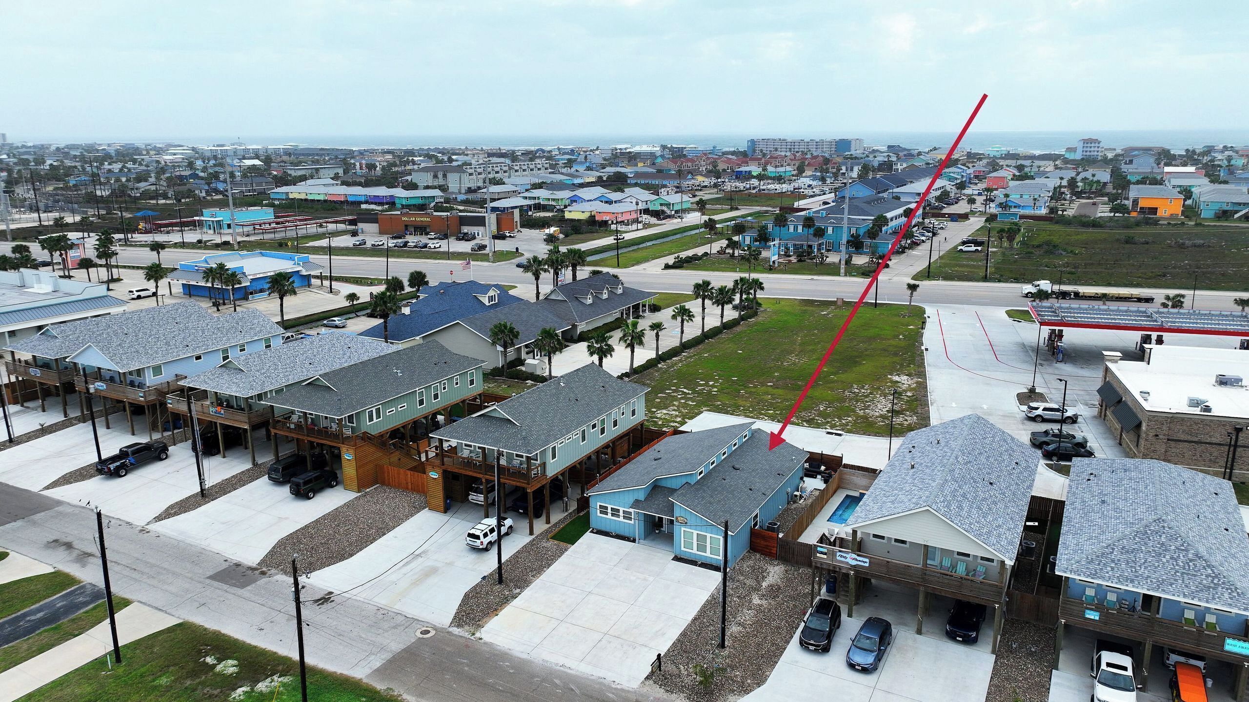A coastal residential area with houses, a Dollar General store, and a marina.