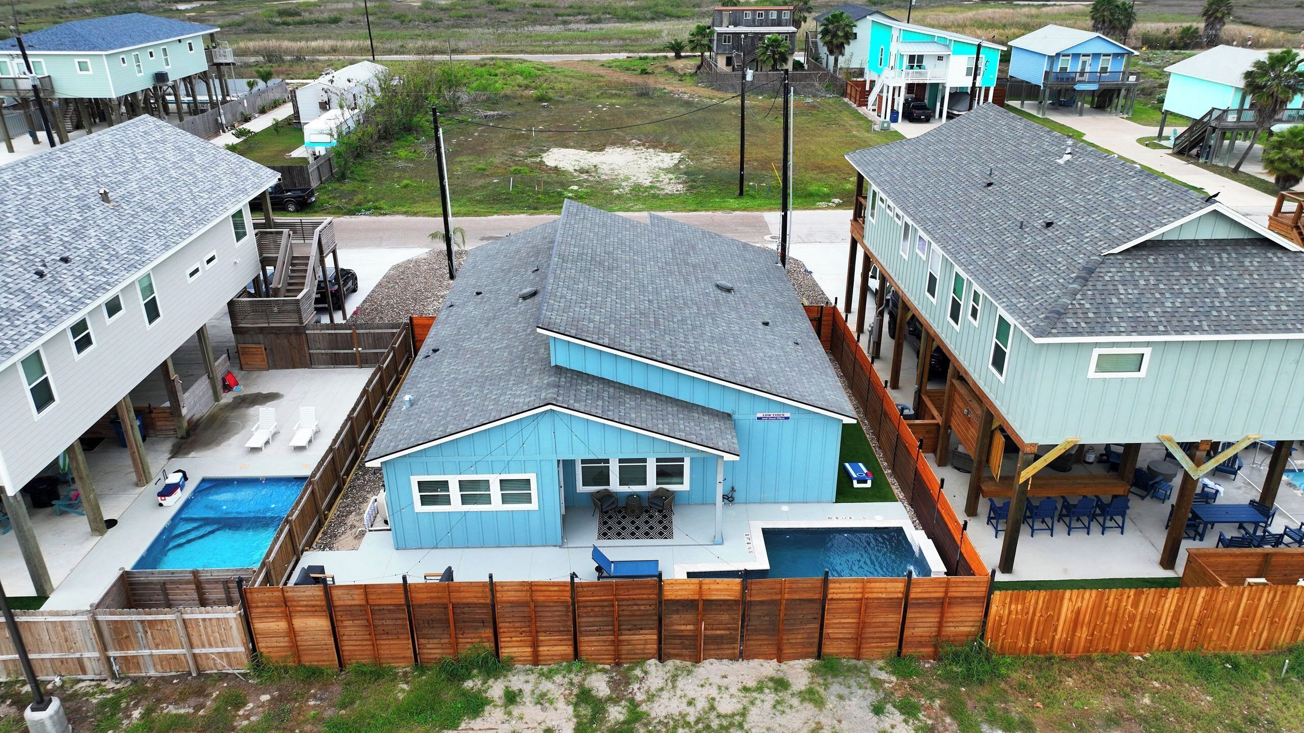 A residential area with houses, a swimming pool, and a wooden deck.