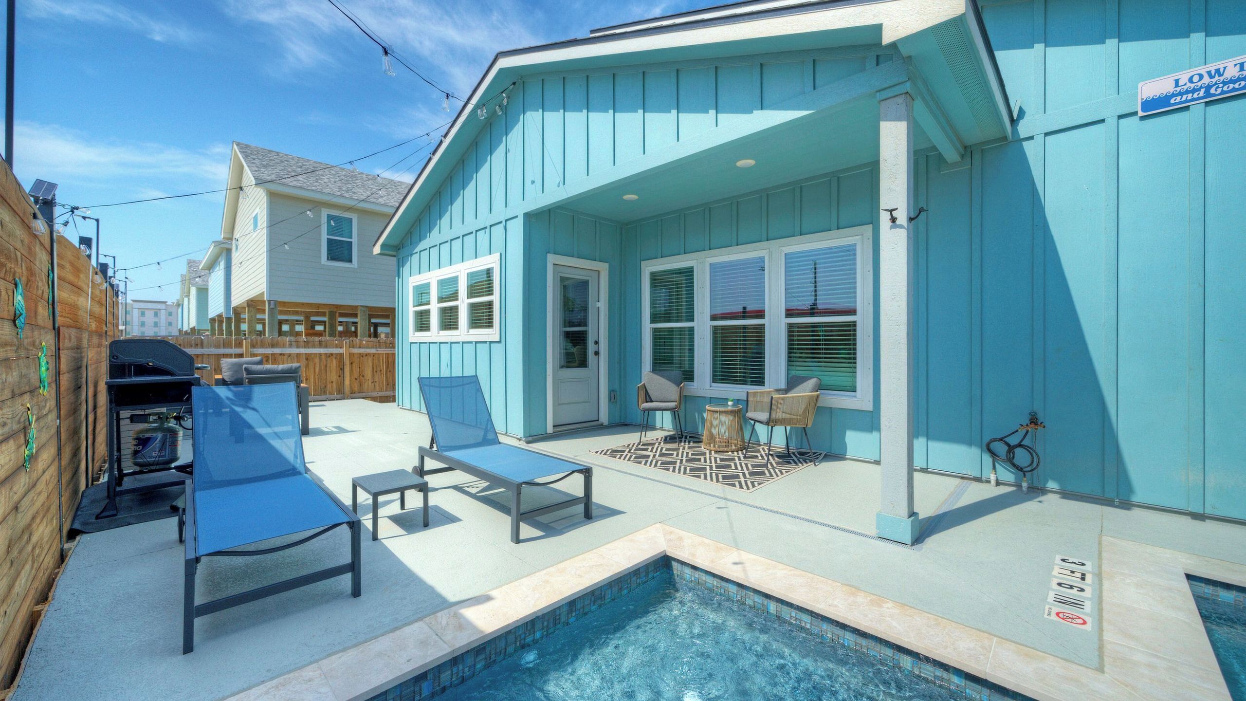 Un espace aménagé au bord de la piscine, comprenant une piscine, des chaises longues et un patio couvert.
