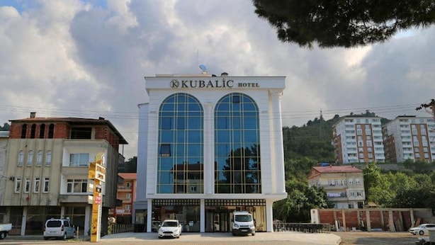 A hotel with a modern facade, large arched windows, and a prominent entrance.