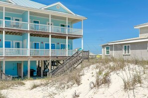 Ein Strandgrundstück mit mehrstöckiger Bebauung, inklusive Balkone und einer Treppe zum Strand.