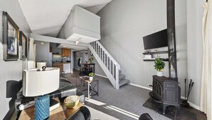 A modern living room with a staircase, a dining area, and a kitchen. - Beach Front Perch by Avantstay Lakefront Condo + Views + Near Dining and Skiing (South Lake Tahoe)
