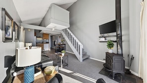 Ein modernes Wohnzimmer mit Treppe, Essbereich und Küche.