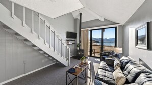 A modern living room with a staircase, a fireplace, a sofa, and a view of the beach. - Beach Front Perch by Avantstay Lakefront Condo + Views + Near Dining and Skiing (South Lake Tahoe)