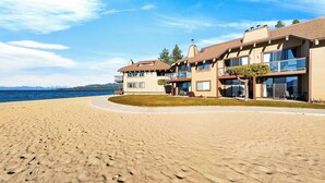 A beachfront property with a curved driveway, a pool, and a view of the sea. - Beach Front Perch by Avantstay Lakefront Condo + Views + Near Dining and Skiing (South Lake Tahoe)